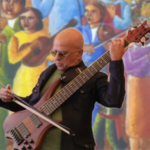 Eduardo Del Signore performing at Art and Tech in a Warming World with a mural backdrop.